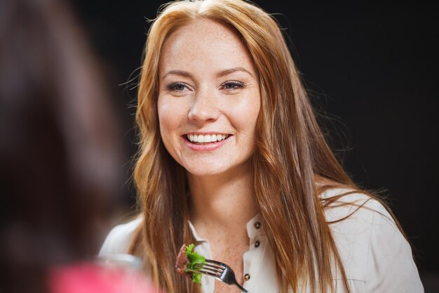 vrije tijd, eten, eten, mensen en vakantie concept - gelukkige vrouw met vrienden die dineren in restaurant