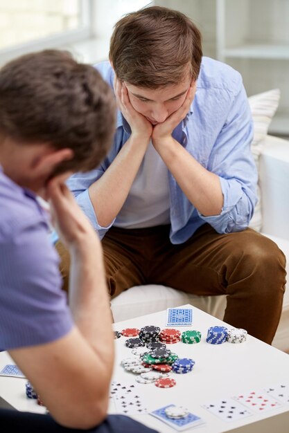 Foto vrije tijd, games, vriendschap, gokken en amusement - close-up van mannelijke vrienden die thuis kaarten