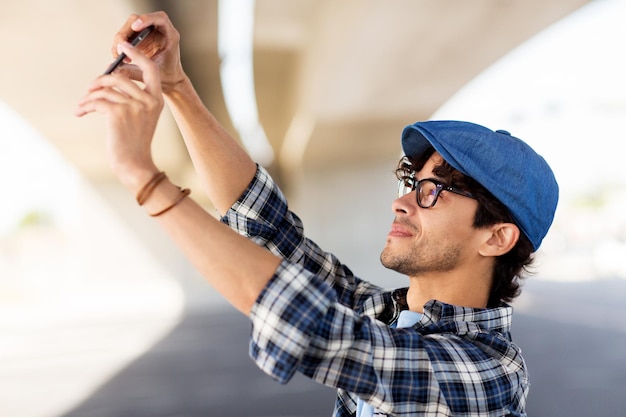 vrije tijd, technologie en mensen concept - hipster man selfie foto nemen door smartphone op straat