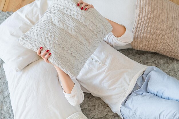 Vrije tijd Thuisrust concept Vrouw liggend op bed en haar gezicht bedekt met kussen