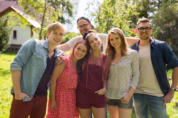 vrije tijd, vakantie, reünie, mensen en vriendschapsconcept - gelukkige tienervrienden knuffelen op zomertuinfeest