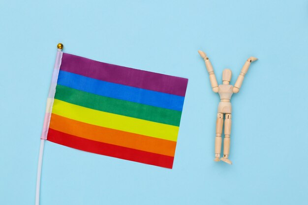 Vrijheid houten marionet en Lgbt regenboogvlag op blauwe achtergrond. Gay parade, vrijheid, tolerantie
