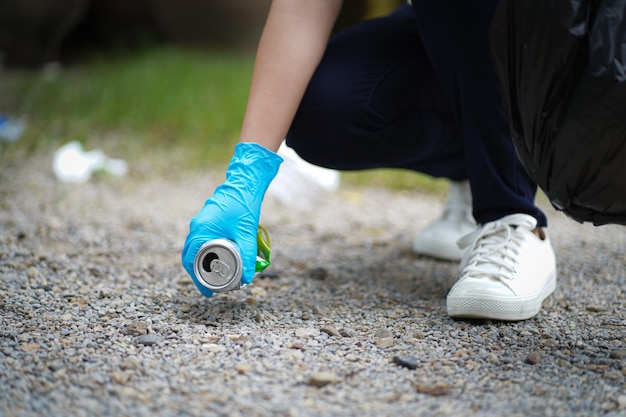 Vrijwilliger liefdadigheidsvrouw hand met vuilniszak en plastic flessenafval voor recycling voor reiniging in het park vrijwilligersconcept hergebruik en vrijwilligerswerk