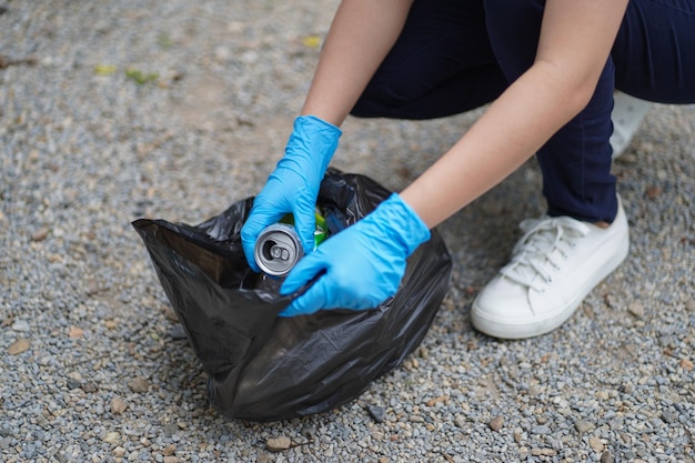 Vrijwilliger liefdadigheidsvrouw hand met vuilniszak en plastic flessenafval voor recycling voor reiniging in het park vrijwilligersconcept hergebruik en vrijwilligerswerk