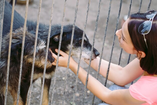 Vrijwilliger meisje in de kinderkamer voor honden. Opvang voor zwerfhonden.