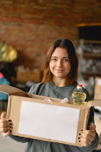 Vrijwilliger tienermeisje bereidt donatieboxen voor mensen voor Schenkingskleding voor vluchtelingen ondersteuning van oorlogsslachtoffers Humanitair hulpconcept Mensen helpen