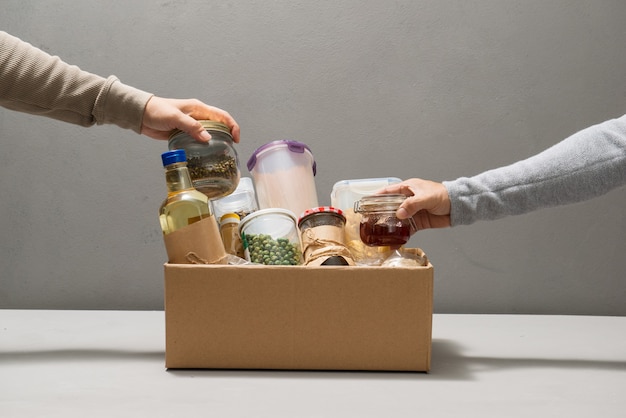 Foto vrijwilligers halen voedsel uit de donatiebox op tafel