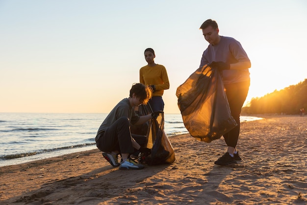 Vrijwilligers van de Dag van de Aarde activisten verzamelen vuilnis schoonmaken van het strand kustzone vrouw en man zet