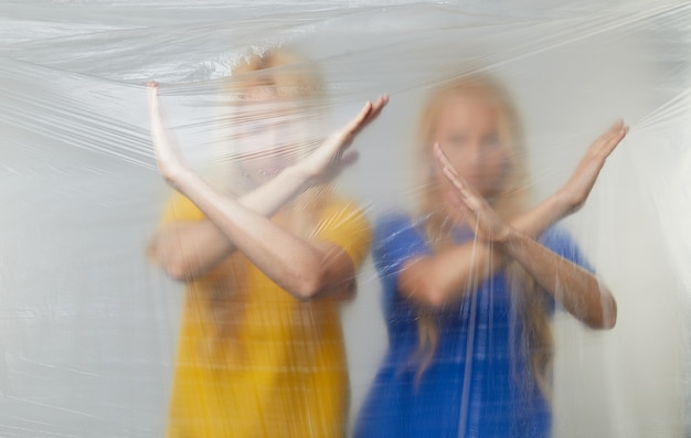 Vrijwilligers van jonge vrouwen in gele en blauwe t-shirts voeren campagne tegen het gebruik van polyethyleen en plastic. afval recycling concept