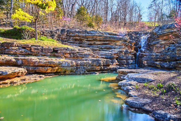 Vroege lente uitzicht op waterval door grillige rotsen in majestueuze wateren