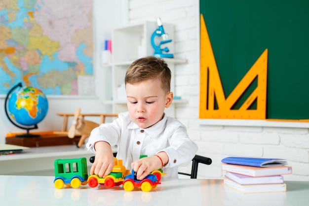 Vroege ontwikkeling Kind thuis of kinderdagverblijf Schattig kind zit binnenshuis aan een bureau Onderwijs