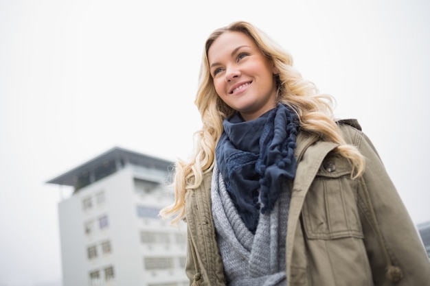 Vrolijk aantrekkelijk blonde die in openlucht stellen