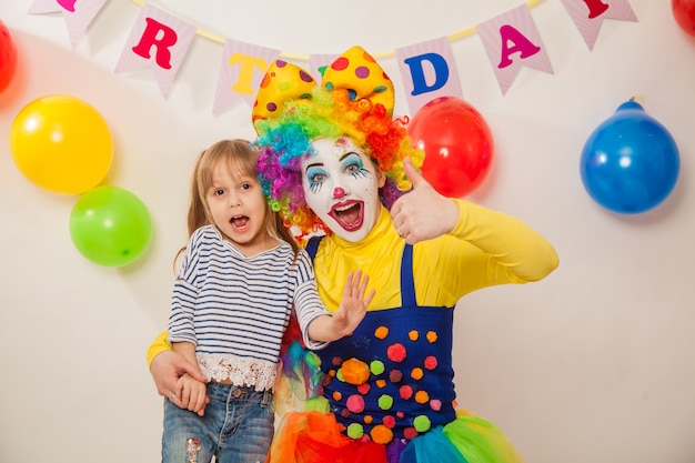 Vrolijk clownmeisje bij de vakantiespelen met het feestvarken