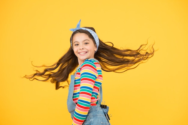 Vrolijk en zorgeloos kind gele achtergrond zomer vakantie en vakantie kleurrijk lente mode vintage stijl hoofddoek gelukkige kinderdag klein meisje express positiviteit Funky stijl schoonheid