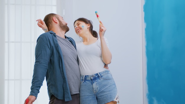 Vrolijk getrouwd stel dat plezier heeft tijdens de renovatie van het huis. Appartement herinrichting en woningbouw tijdens renovatie en verbetering. Reparatie en decoreren.