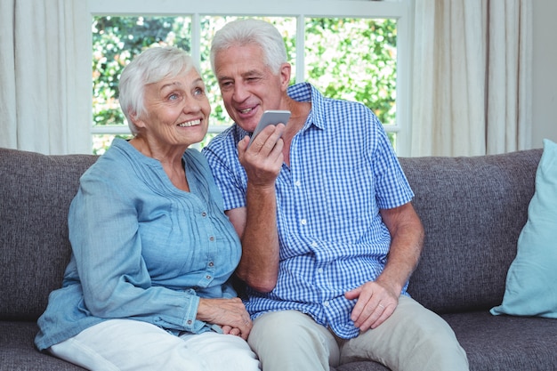 Vrolijk hoger paar dat aan muziek via telefoon luistert