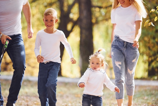 Vrolijk jong gezin maakt samen een wandeling in een herfstpark.