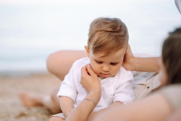 Vrolijk jong gezin met kleine babyjongen die samen tijd doorbrengt op het strand