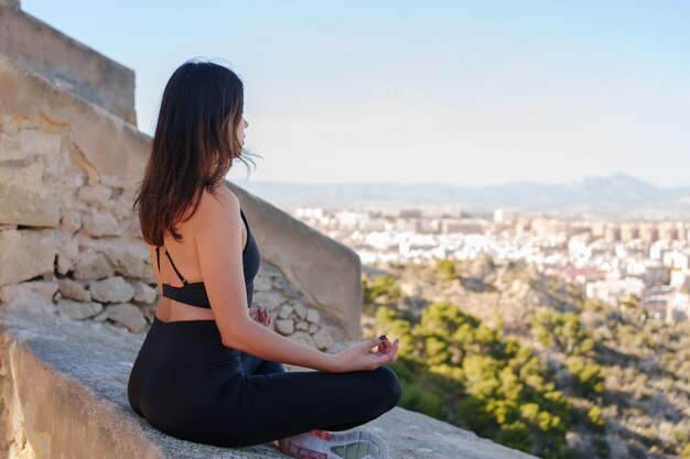 Foto vrolijk jong meisje doet yoga houdingen buitenshuis