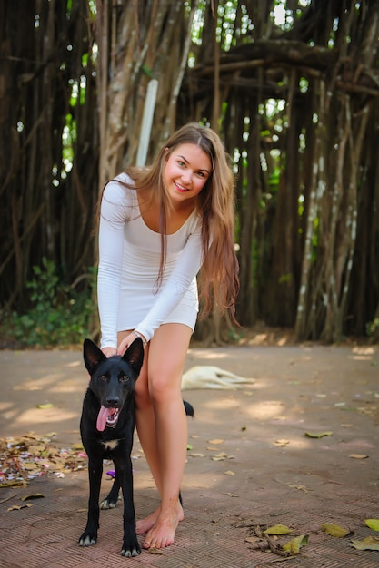 Vrolijk jong meisje op wandeling in het park met haar hond