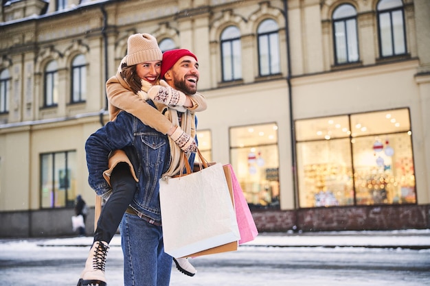 Vrolijk jong stel gaat winkelen op winterdag