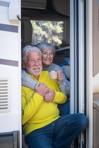 Vrolijk, kaukasisch, senior paar, zittende, aan de deur, van, hun, camper, camper, vasthouden, koffiekopje, kijken weg, glimlachend, aantrekkelijk, ouderen, het genieten van, vrijheid, vakantie, reizen, in, de, bos