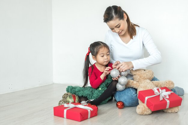 Vrolijk kerstfeest en fijne feestdagen! Moeder en dochter versieren de kerst