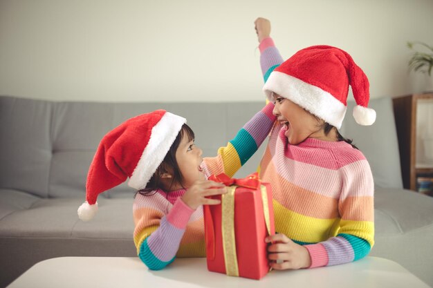 Vrolijk kerstfeest, gelukkige broers en zussen met een cadeau thuis