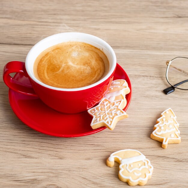 Vrolijk kerstfeest met zelfgemaakte koekjes en koffiekopje op houten tafel achtergrond. Kerstavond, feest, vakantie en gelukkig nieuwjaarsconcept