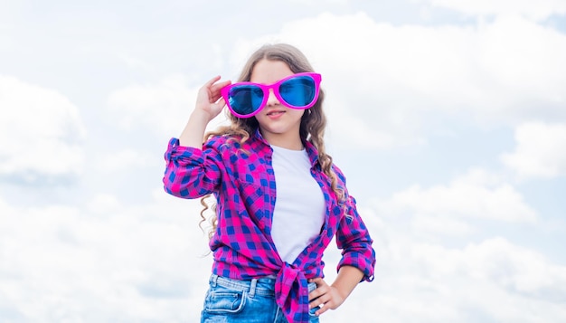 Vrolijk kind draagt casual denimkleding en grappige brillen voor buitenfeesten