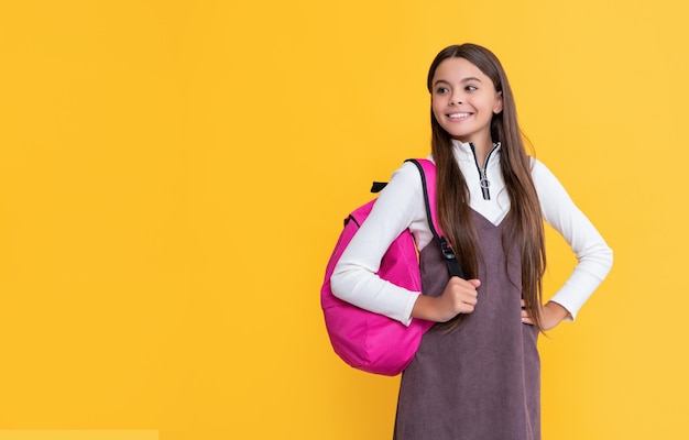 Vrolijk kind met schooltas op gele achtergrond