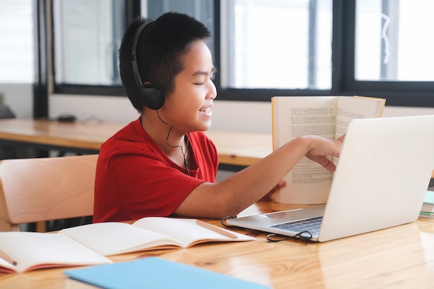 Vrolijk kind opgewonden met behulp van computer voor online leren. Online onderwijs en zelfstudie en homeschooling-concept.