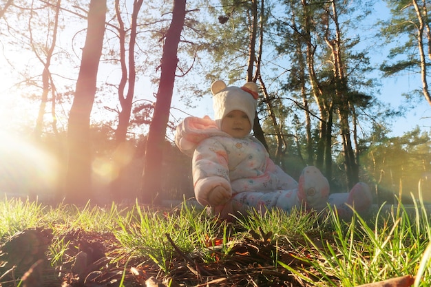 Vrolijk klein babymeisje speelt met kegels in het bos