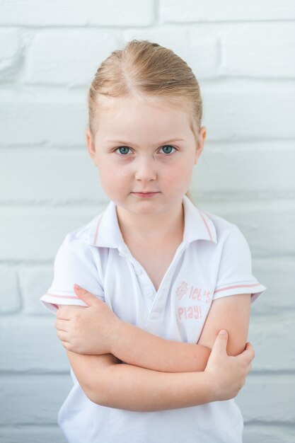 Vrolijk lachend babymeisje portret op een witte muur