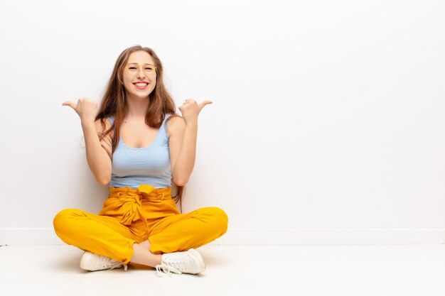 vrolijk lachend en blij kijkend, onbezorgd en positief met beide duimen omhoog