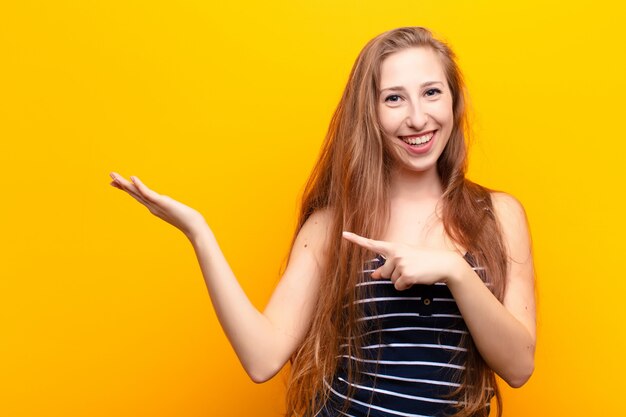 vrolijk lachend en wijzend om de ruimte op de palm aan de zijkant te kopiëren, een object te tonen of te adverteren