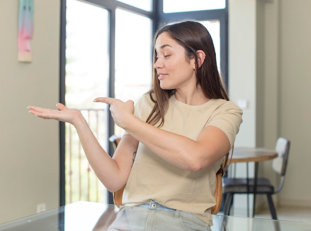 Foto vrolijk lachend met een vriendelijke, zelfverzekerde positieve uitstraling die een object of concept aanbiedt en toont