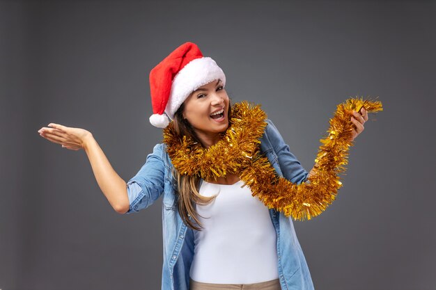 Vrolijk lachende jonge vrouw met kerstmuts op het hoofd kerstavond vieren.