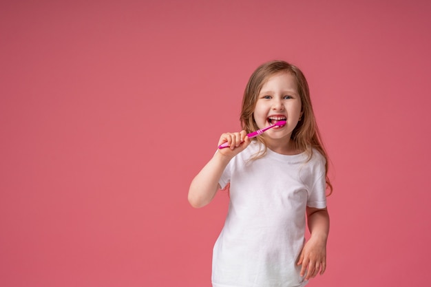 Vrolijk meisje 4 jaar oud ,, glimlachend, haar tanden poetsen