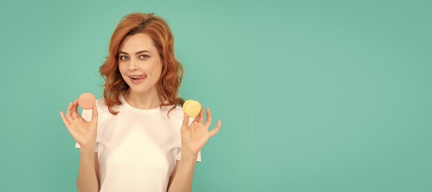 Foto vrolijk meisje houdt zoete macaron frans koekje op blauwe achtergrond vrouw geïsoleerd gezicht portret banner met mock up copyspace