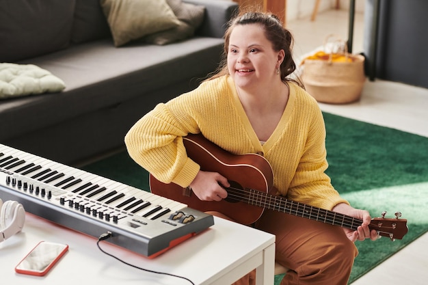 Vrolijk meisje met het syndroom van Down die gitaar speelt