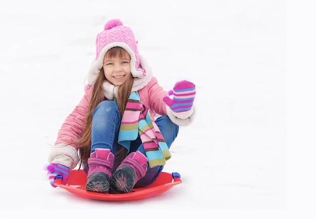 Vrolijk meisje met plezier en rodelen op sneeuw