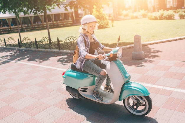 Vrolijk meisje scooter rijden in de stad