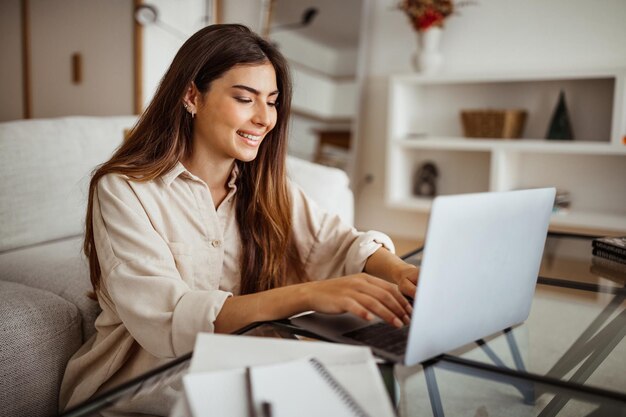 Vrolijk millennial gemengd ras vrouwelijk typen op laptop heeft video cal chat in lichte kamer interieur