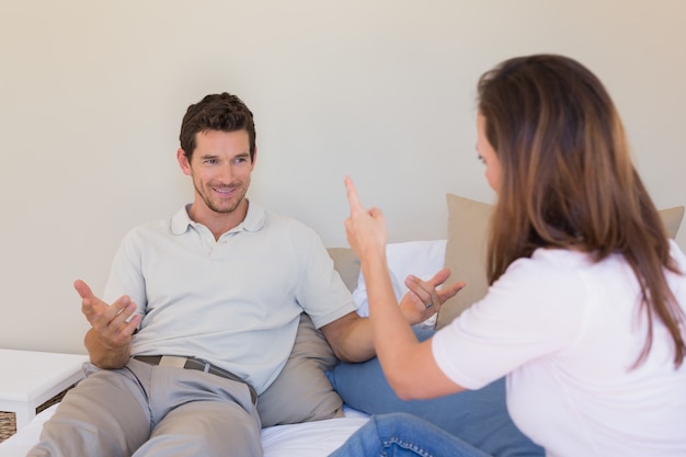 Vrolijk paar dat een gesprek in slaapkamer heeft