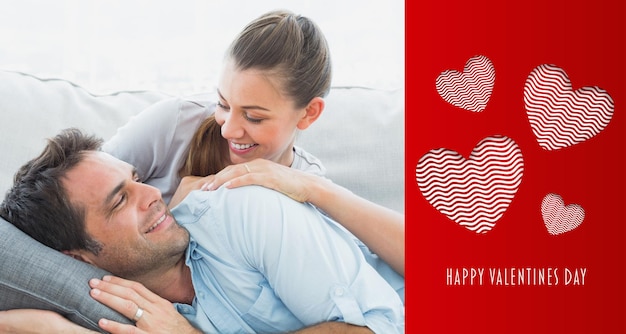 Vrolijk paar dat op hun bank ontspant en naar elkaar glimlacht tegen een schattig valentijnsbericht