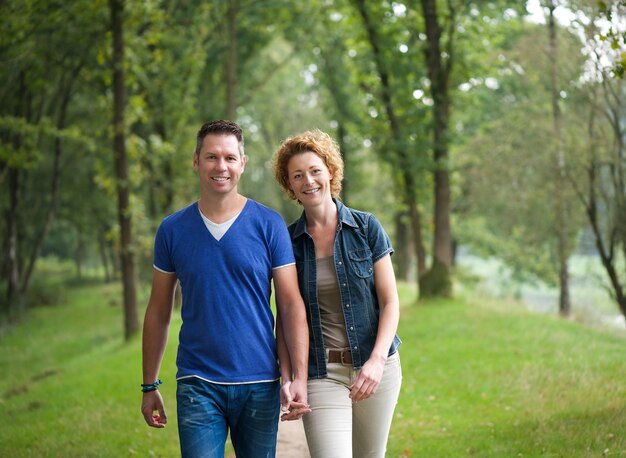 Vrolijk paar die samen in het hout lopen