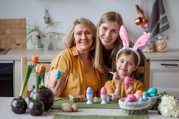 Vrolijk Pasen bejaarde grootmoeder en vrouw moeder met dochtertje met konijnenoren