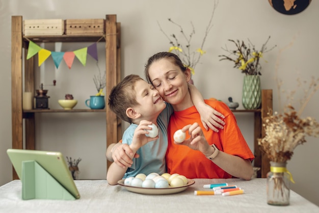 Foto vrolijk pasen met je familie moeder en zoon bereiden zich voor op de lente pasen door vrolijk feest eieren