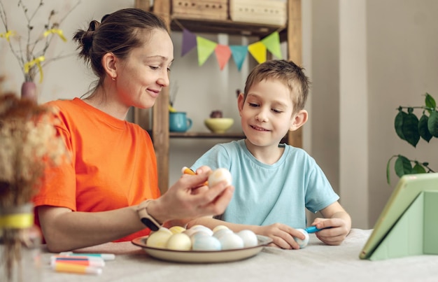 Foto vrolijk pasen met je familie moeder en zoon bereiden zich voor op de lente pasen door vrolijk feest eieren